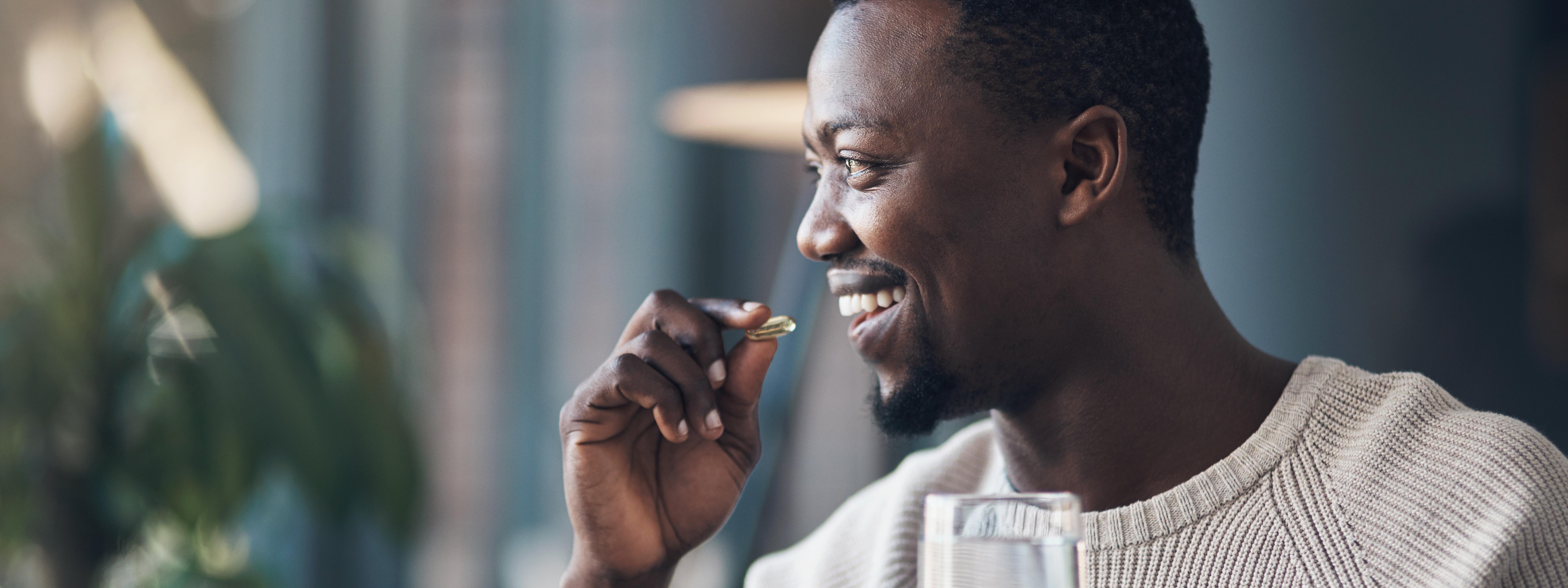 Man taking his morning supplements: fish oil, probiotic, multivitamin